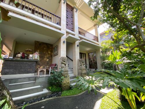 a house with stairs leading to the front entrance at ThreeWin Homestay in Ubud