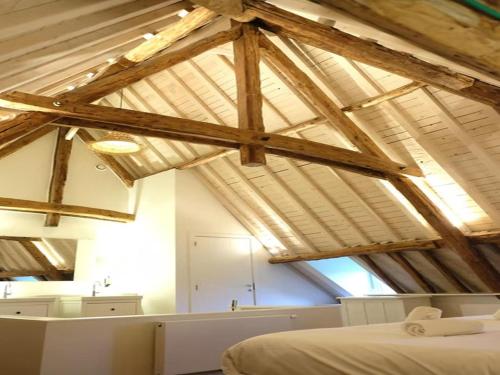 a room with a bed and some wooden beams at Historic Gardener s House in Haltinne in Haltinne