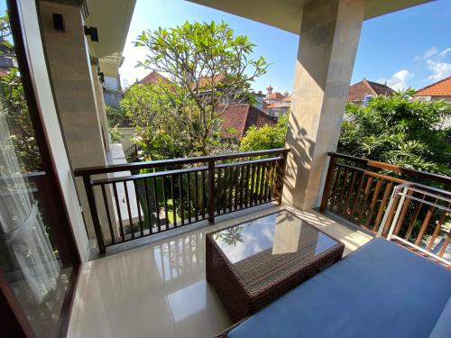 a balcony with a view of trees and bushes at ThreeWin Homestay in Ubud
