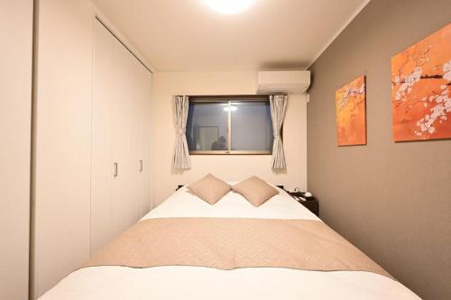 un dormitorio con una cama y una ventana en 福助桜和小築鶴橋 6 minutes from Tsuruhashi Station 4LDK, 8 people, en Osaka