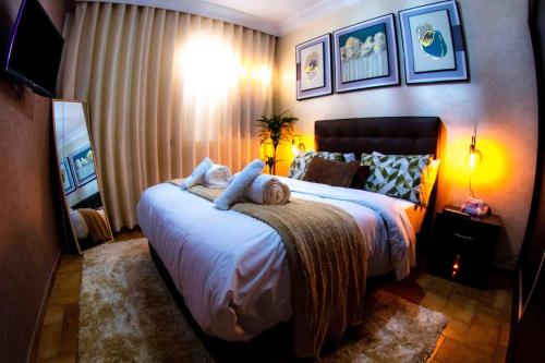 ラバトにあるCozy apartment in Rabat Agdalのベッドルーム1室(大型ベッド1台、動物2匹の詰め物付)