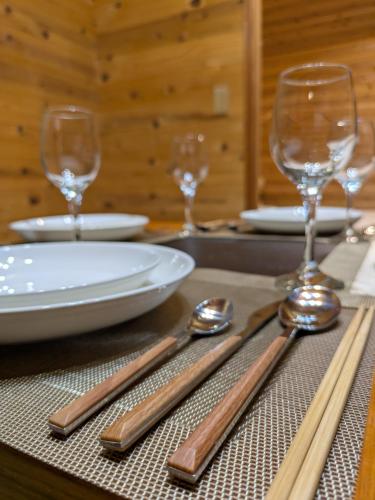 a table with twooons and two wine glasses on it at Morifuneya Ine - 森舟屋 伊根 - in Kameshima