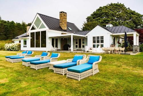 a group of wicker chairs in front of a house at The Cottage at Seaside in Friendship in Friendship