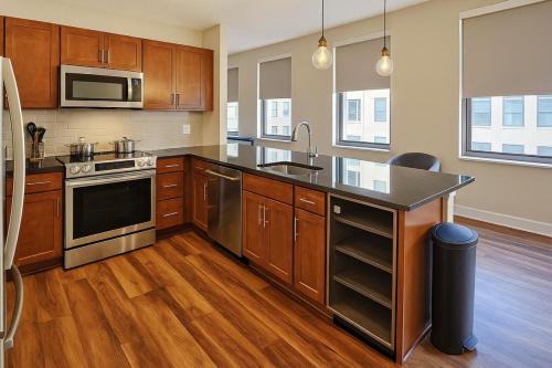 a kitchen with wooden cabinets and stainless steel appliances at Spacious Downtown SQ Stadium, Casino, R&R HoF! in Cleveland