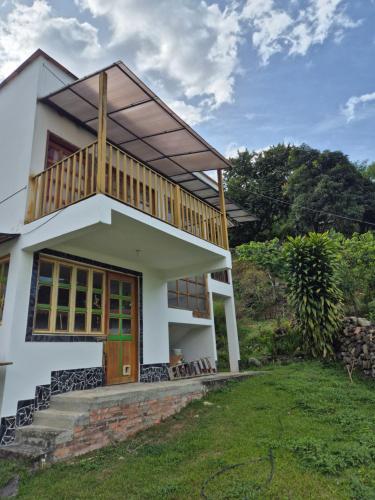 a house with a balcony on top of it at Hotel Campestre Villa Nico in Bochalema