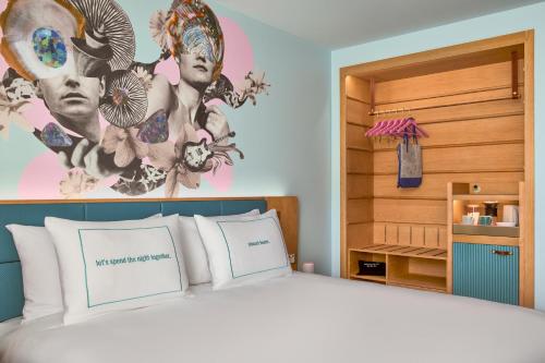 a bedroom with a bed and a painting on the wall at 25hours Hotel Sydney The Olympia in Sydney