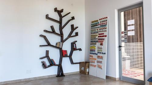 a wall with a tree sculpture on a wall at Hotel Kapsul Vlore in Vlorë