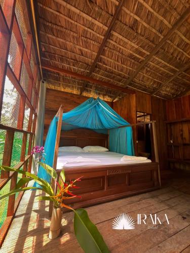 a bed in a room with a blue tent at Ecohotel Iraka Cabañas Privadas en Selva y Playa in Bahía Solano
