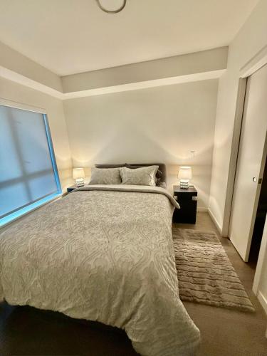 a bedroom with a large bed and a window at Victoria Colwood Place in Colwood