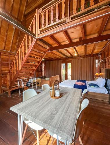 a dining room with a table and a bed at Danial Cabin Dieng in Diyeng