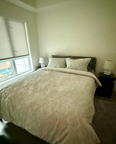 a bedroom with a large bed and a window at Victoria Colwood Place in Colwood