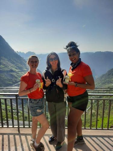 three women posing for a picture in front of a mountain at Napoli Hostel Cat Ba in Cat Ba