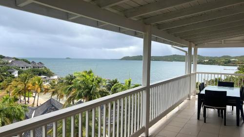 a balcony with a table and a view of the ocean at Vashays Caribbean Hideaway in Freetown Village