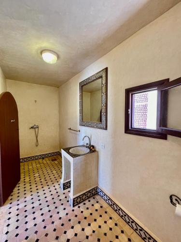 a bathroom with a sink and a mirror on the wall at Bab Rimal - Desert Hotel in M'hamid El Ghizlane in Mhamid