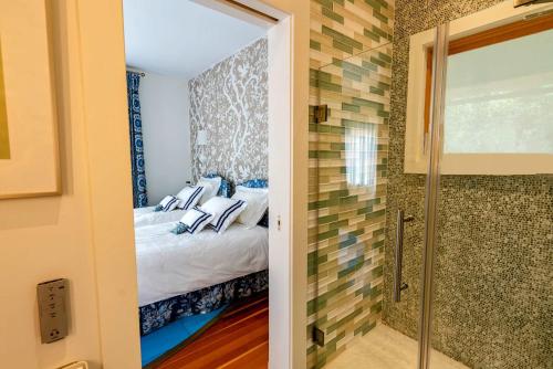 a bedroom with a bed and a walk in shower at The Lodge at Seaside in Friendship in Friendship
