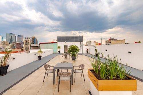 a balcony with a table and chairs on a roof at Alure Condesa in Mexico City