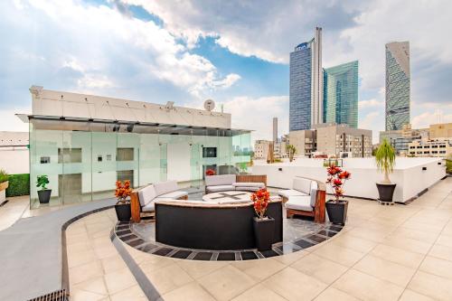 a rooftop patio with a table and chairs on a building at Alure Condesa in Mexico City