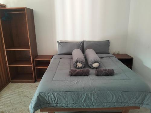 a bed with two pillows on top of it at Villa Santai Mentawai in Tuapejat