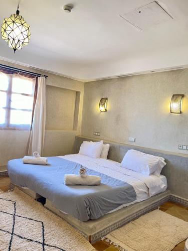 a bedroom with a large bed with towels on it at Bab Rimal - Desert Hotel in M'hamid El Ghizlane in Mhamid