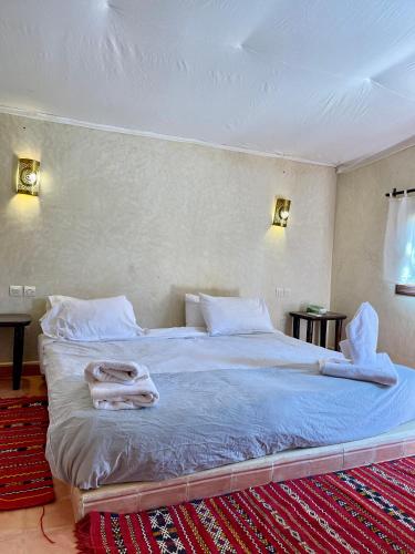 a bedroom with a bed with a towel on it at Bab Rimal - Desert Hotel in M'hamid El Ghizlane in Mhamid