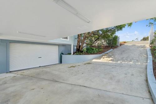 a house with a garage and a driveway at Coastal Panorama - Spectacular Views, Sleeps 8 in Coffs Harbour