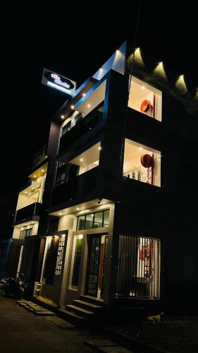 a building with a sign on the side of it at night at The Chalet - Cozy Villa with Mini Pool, near Eden Blue Flag Beach, Pondicherry - JR Groups in Puducherry