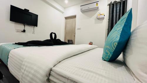 a bedroom with two beds and a tv on the wall at The Chalet - Cozy Villa with Mini Pool, near Eden Blue Flag Beach, Pondicherry - JR Groups in Puducherry