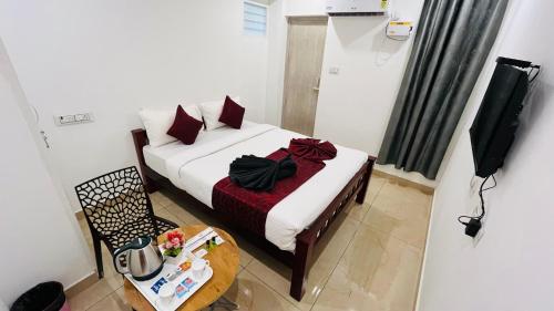 a bedroom with a bed and a table and a tv at The Chalet - Cozy Villa with Mini Pool, near Eden Blue Flag Beach, Pondicherry - JR Groups in Puducherry