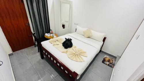 a black cat sitting on a bed with two blankets at The Chalet - Cozy Villa with Mini Pool, near Eden Blue Flag Beach, Pondicherry - JR Groups in Puducherry