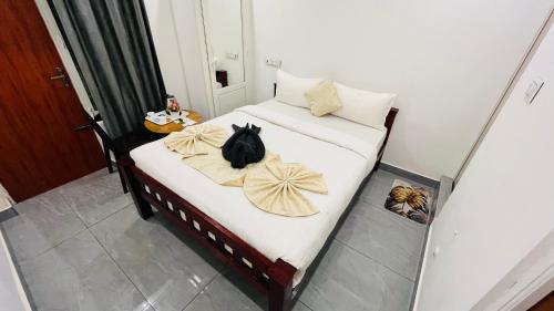 a black cat sitting on a bed with towels at The Chalet - Cozy Villa with Mini Pool, near Eden Blue Flag Beach, Pondicherry - JR Groups in Puducherry