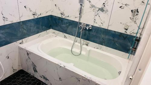 a bath tub with a shower in a bathroom at The Chalet - Cozy Villa with Mini Pool, near Eden Blue Flag Beach, Pondicherry - JR Groups in Puducherry