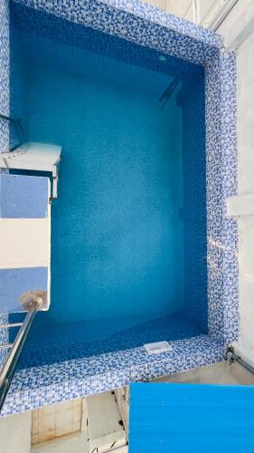 a swimming pool with blue tile on the wall at The Chalet - Cozy Villa with Mini Pool, near Eden Blue Flag Beach, Pondicherry - JR Groups in Puducherry