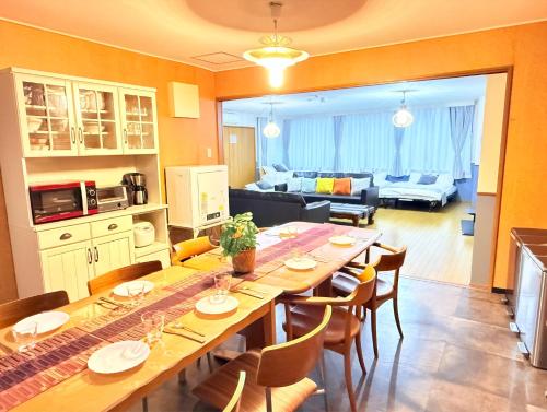 a kitchen and living room with a long table and chairs at M-Haneda Lex Apartment 137sqm 3BDR Max24 PPL 1min from Sta FreeParking in Tokyo