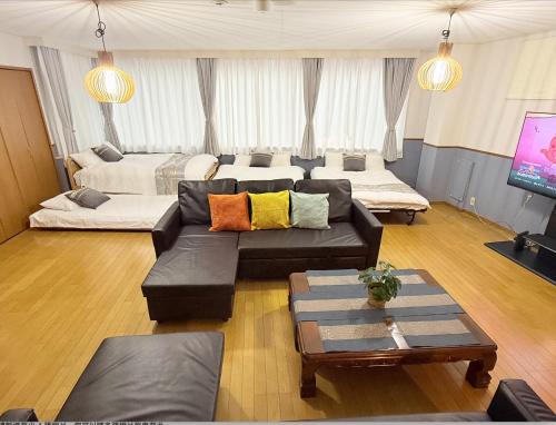 a living room with a couch and a tv at M-Haneda Lex Apartment 137sqm 3BDR Max24 PPL 1min from Sta FreeParking in Tokyo