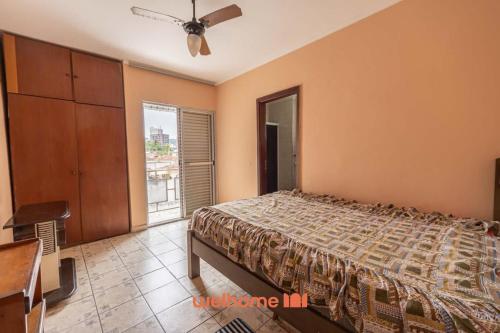 um quarto com uma cama, uma cômoda e uma janela em Apartamento em Praia Grande a 600 metros do mar na Praia Grande