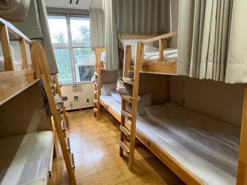 a room with three bunk beds and a window at 三陸アクティブ in Ōfunato
