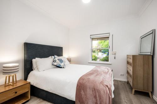 una camera da letto con un letto grande e una finestra di Seaside Victor Harbour Apartment a Victor Harbor
