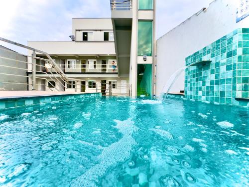 a swimming pool with a water fountain in a building at Studio A 350m PRAIA com Piscina 6 in Piçarras