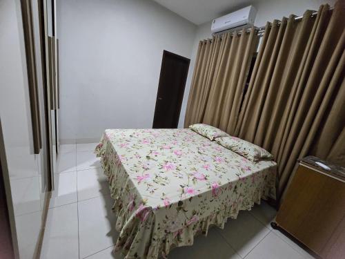 a small bed in a room next to a curtain at Casa Fernandes in Rio Verde