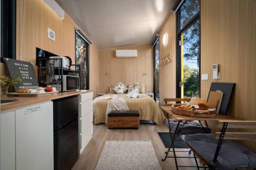 a room with a bed and a kitchen with a table at Jumbuk Retreat by Tiny Away 