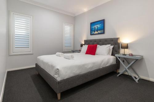 a bedroom with a large white bed with a night stand at Lizzie Bliss in Elizabeth Beach