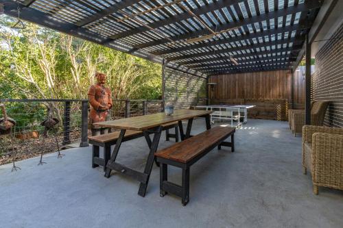 a patio with a wooden table and a statue at Lizzie Bliss in Elizabeth Beach
