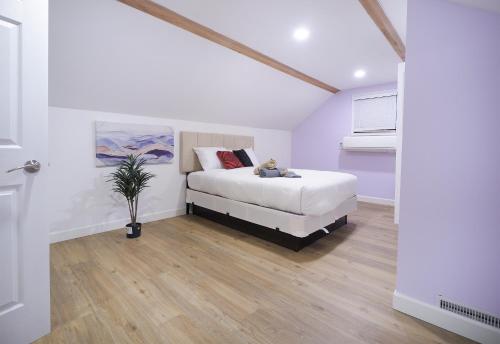 a white bedroom with a bed and a potted plant at Golf Course Views House in Sioux City