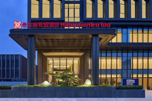 a building with a hilton garden inn sign on it at Hilton Garden Inn Chongqing Yubei Central Park in Chongqing
