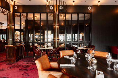 a restaurant with tables and chairs in a room at Hotel Dali Val d'Europe, Tapestry Collection by Hilton in Chanteloup-en-Brie
