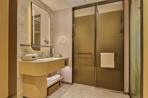a bathroom with a sink and a shower at Hilton Garden Inn Chongqing Yubei Central Park in Chongqing