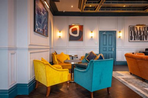a restaurant with yellow and blue chairs and a table at Dover Marina Hotel & Spa, Tapestry Collection by Hilton in Dover