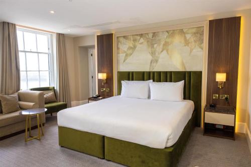 a hotel room with a large bed and a chair at Dover Marina Hotel & Spa, Tapestry Collection by Hilton in Dover
