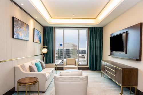 a living room with a couch and a tv at Blossom Hotel Houston, Curio Collection by Hilton in Houston