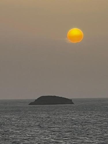 an island in the ocean with a yellow ball in the sky at Vashays Caribbean Hideaway in Freetown Village